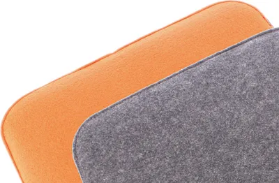 Close-up view of two fabric cushions, one orange and one gray, layered on top of each other.