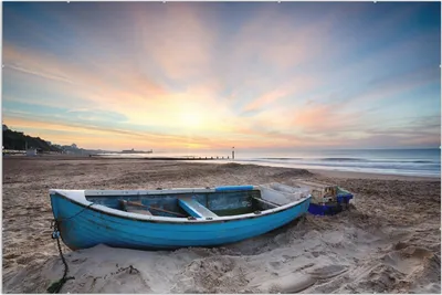 Produktbild von Wallario Wandbild Fischerboot am Strand bei Sonnenuntergang, Größe: 61 x 91,5 cm, Poster mit rahmenlosen Bildhalter