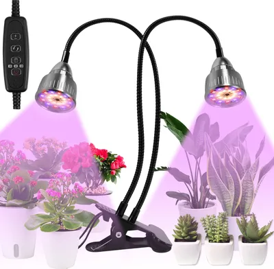 Two LED grow lights with flexible goosenecks are clipped onto a stand, illuminating several potted plants with purple light.