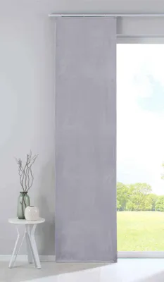 A grey panel curtain hangs in front of a window with a view of a garden.