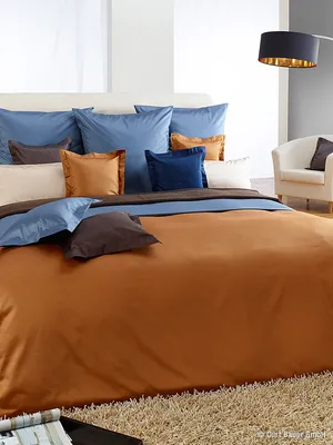 A neatly made bed with multiple pillows and a duvet.