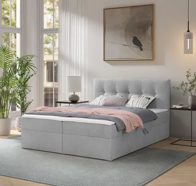 A bedroom scene with a bed, plants, and a painting on the wall.