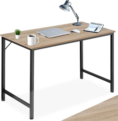 A desk with a laptop, mug, lamp, and notebook.