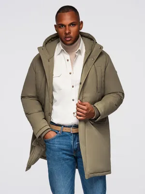 A man wearing a parka, shirt, and jeans.