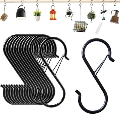 A collection of black S-hooks hanging on a wooden rod, with various decorative hanging items above them.