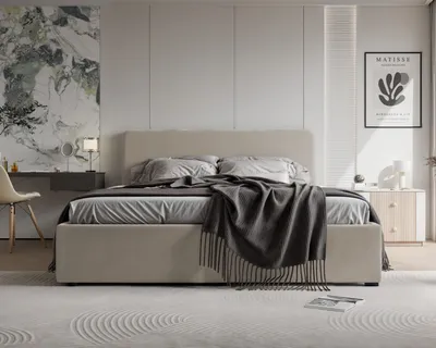 A bedroom scene featuring a large bed with bedding and a throw blanket, a vanity table with a chair, and a nightstand with decor.
