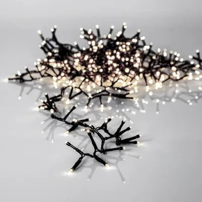 A string of white LED lights with black wires, arranged in a cluster on a reflective surface.