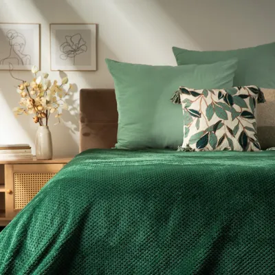 A bedroom setting with a bed, pillows, and a nightstand.