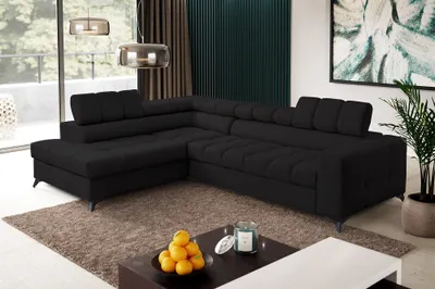 A modern living room with a black sectional sofa, coffee table, and artwork.