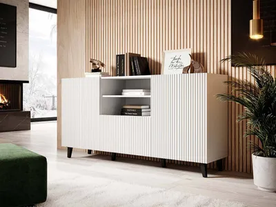 A modern living room with a white sideboard, fireplace, and plant.