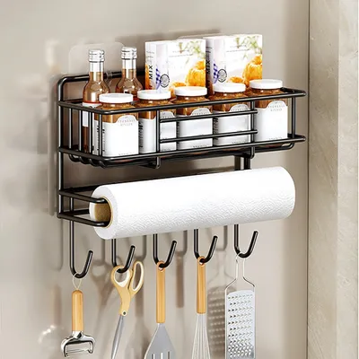 A black metal kitchen shelf organizer mounted on a wall, holding various jars, bottles, and kitchen utensils, with a roll of paper towels on the lower rack.
