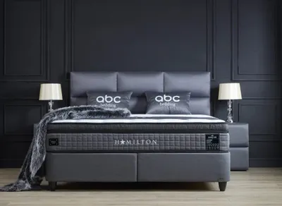 A luxurious bed set in a dark, modern bedroom.