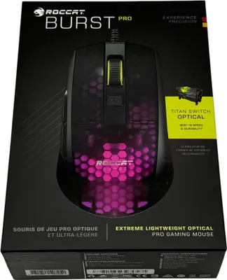 The image shows the packaging of a Roccat Burst Pro gaming mouse. The packaging is black with purple and yellow accents, featuring a clear window that displays the mouse inside. Text on the packaging highlights the product's features and brand.