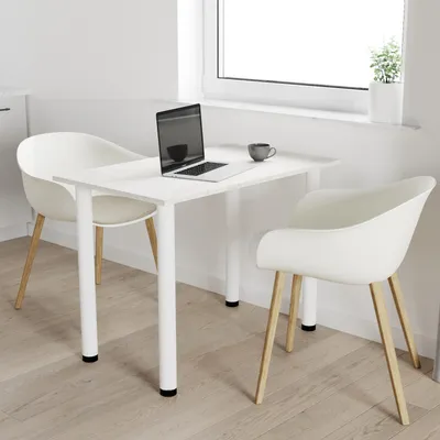 A white dining table with two white chairs, a laptop, and a coffee cup on it, placed near a window.