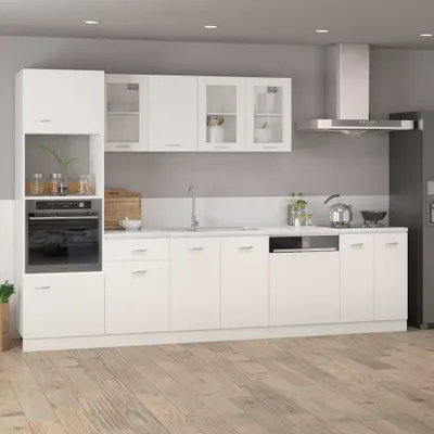 A modern white kitchen with white cabinets, a built-in oven, and a stainless steel range hood.