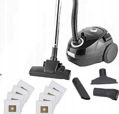 A black vacuum cleaner with accessories and dust bags laid out on a white background.