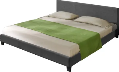A bed with a gray fabric frame and headboard, dressed with beige sheets and two pillows, and a green runner across the foot of the bed.