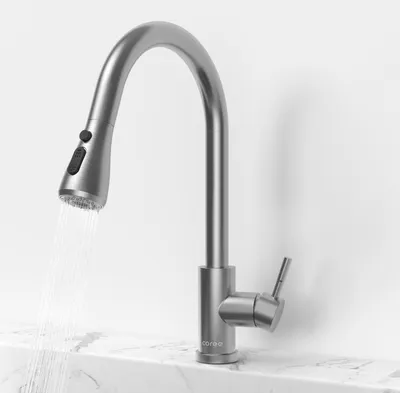 A stainless steel kitchen faucet with a pull-out spout is shown in operation, with water flowing from the spout.