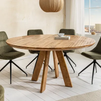 A round wooden dining table with four green chairs in a dining room setting.