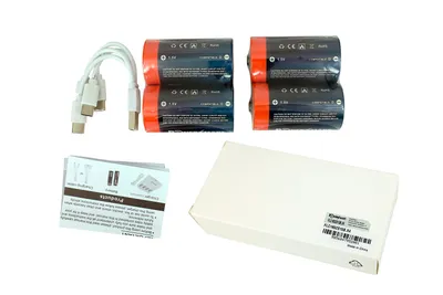A collection of rechargeable batteries, a charging cable, and a small instruction booklet are laid out on a white background.