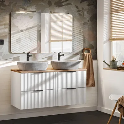 A modern bathroom vanity with double sinks and a mirror, set against a floral wallpaper.