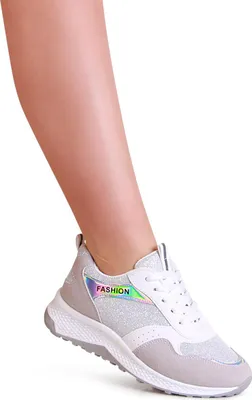 A person's leg wearing a white sneaker with glitter and iridescent details.