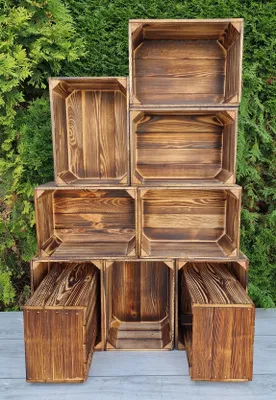 A stack of wooden crates arranged in a display against a green leafy background.