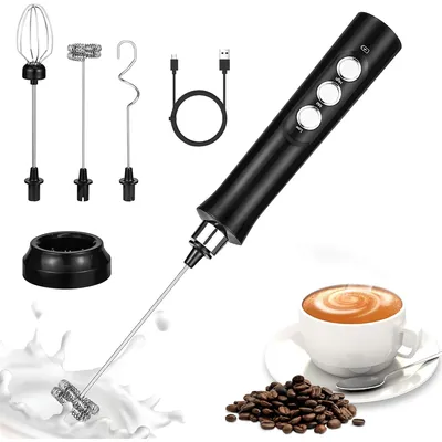 A black electric hand mixer with multiple attachments, a charging cable, a stand, a cup of coffee, and coffee beans are displayed against a white background.