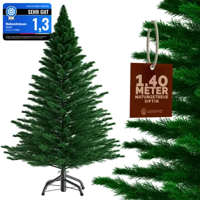 A green artificial Christmas tree with a brown tag hanging from a branch.