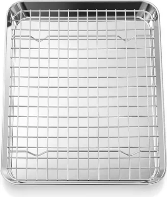 A clean, top-down view of a stainless steel baking sheet with a wire cooling rack inside.