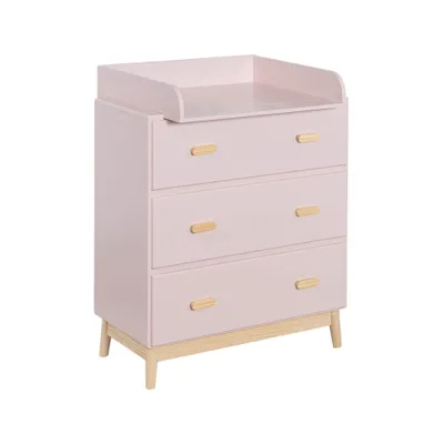 A pink changing table with wooden accents and three drawers, shown against a white background.
