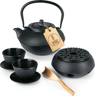 A black cast iron tea set displayed on a white background.