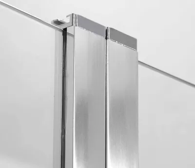 A close-up view of a shower enclosure's corner, showing the glass and metal frame.
