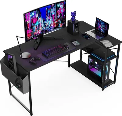 A black L-shaped gaming desk with a computer, monitor, laptop, keyboard, mouse, and accessories.