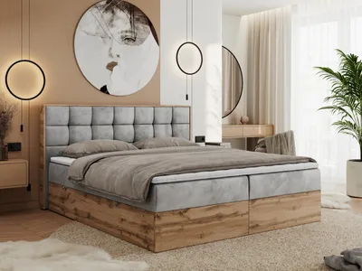 A bedroom scene featuring a large bed with a tufted headboard and wooden base, decorated with modern lighting and artwork.