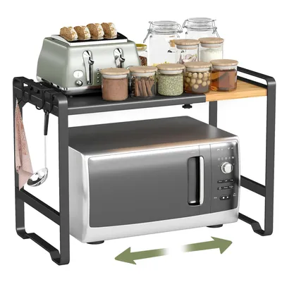 A kitchen counter with a microwave and an expandable shelf above it.