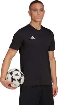 A man wearing a black Adidas t-shirt holds a soccer ball.