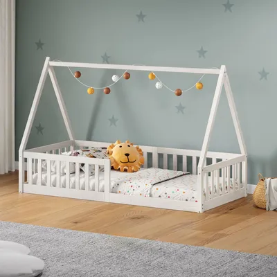 A child's bed with a lion pillow and decorative lights.