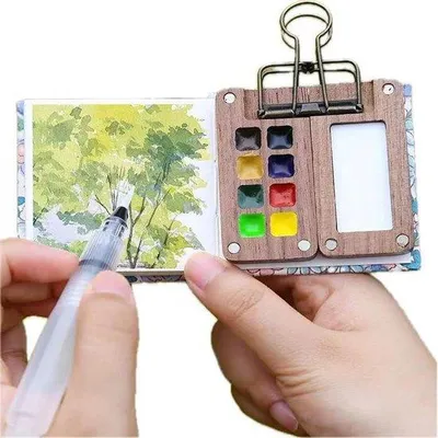 Obrázok produktu pre Miniatúrny skicár na akvarel s drevenou podložkou 6 x 6 cm, mosadzná spona, určený na akvarelové a akrylové farby