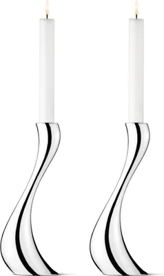 Two silver candle holders with white candles on a white background.