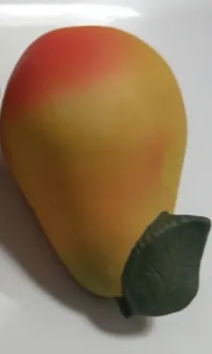 Eine kleine, birnenförmige Keramikfigur. Die Birne ist in Gelb- und Orangetönen bemalt.