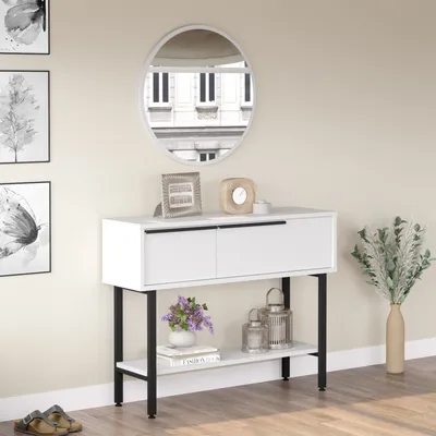A white console table with black legs is shown in a room with artwork on the wall and a mirror above the table.