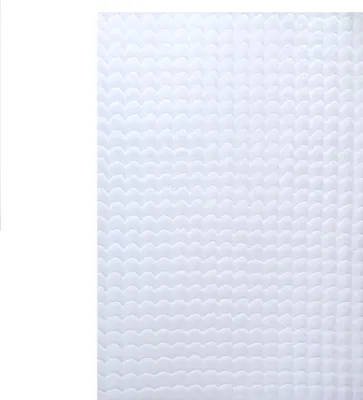A close-up view of a white, textured rug with a wave-like pattern.