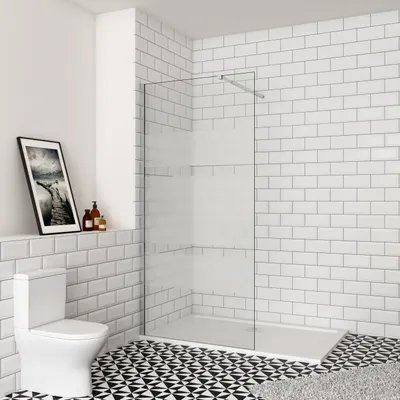 A modern bathroom with a toilet, a walk-in shower, and decorative tiling.