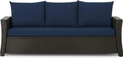 A front view of a dark gray wicker sofa with navy blue cushions.