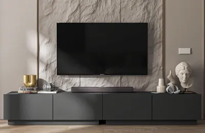 A modern living room setup featuring a TV stand with a TV mounted above it, and decorative items on the stand.