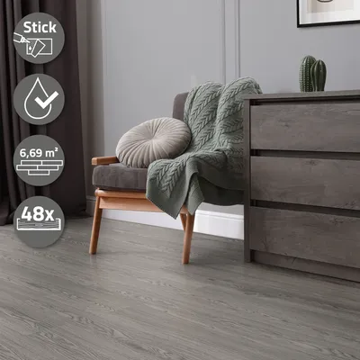A living room scene with a chair, blanket, and dresser, showcasing the flooring.