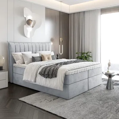A modern bedroom with a large bed, bedside table, and curtains.