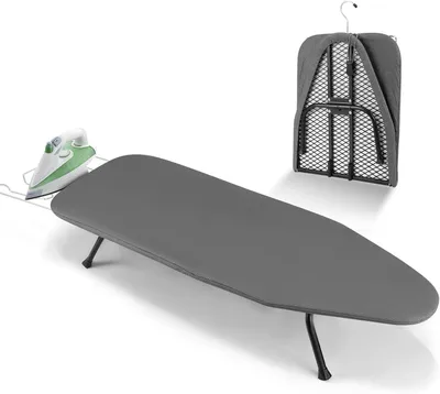 A small, foldable ironing board with an iron resting on its attached holder, and the ironing board folded and hung on a hook in the background.