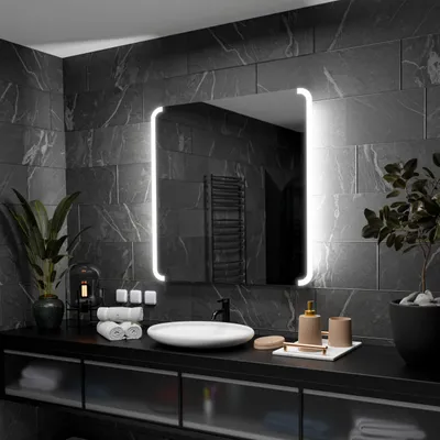 A modern bathroom vanity with a large LED-lit mirror, sink, and various accessories.